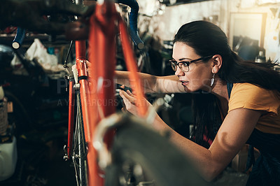 Buy stock photo Woman, bicycle mechanic and fix with inspection for maintenance or small business at repair shop check. Young female person or cycling engineer working on bike with tools or equipment at workshop