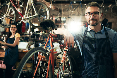 Buy stock photo Serious, portrait and mechanic man in bicycle shop working in store or cycling workshop for repair. Face, bike technician and confident male person, worker or mature professional with glasses.