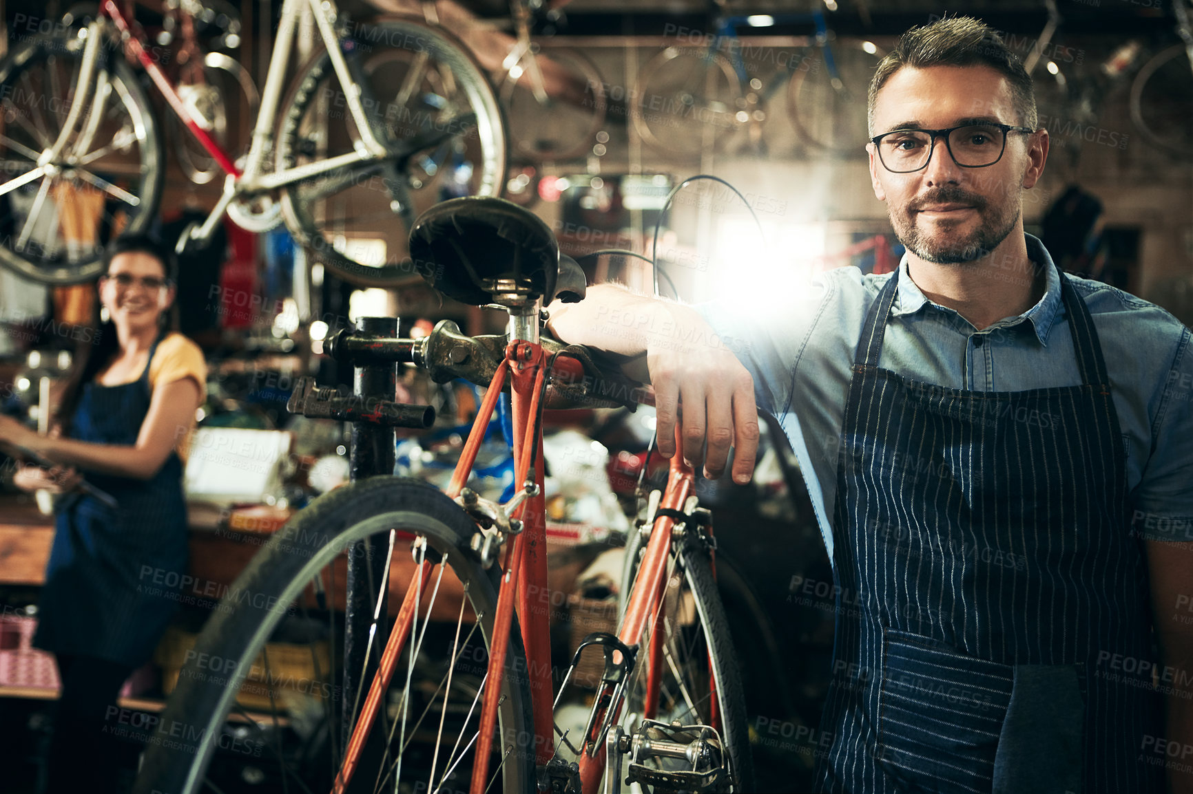 Buy stock photo Serious, portrait and mechanic man in bicycle shop working in store or cycling workshop for repair. Face, bike technician and confident male person, worker or mature professional with glasses.