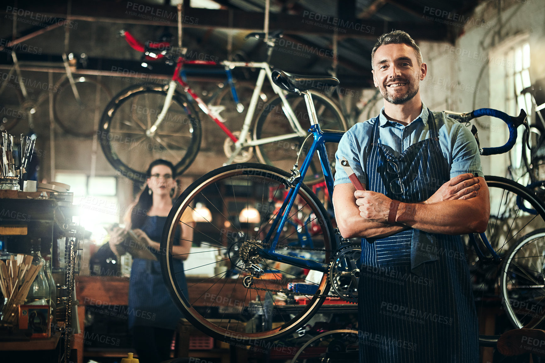 Buy stock photo Mechanic, portrait and arms crossed for bicycle repair shop or maintenance garage. Bike, man and service with a professional with smile for startup job, small business and workshop for fixing