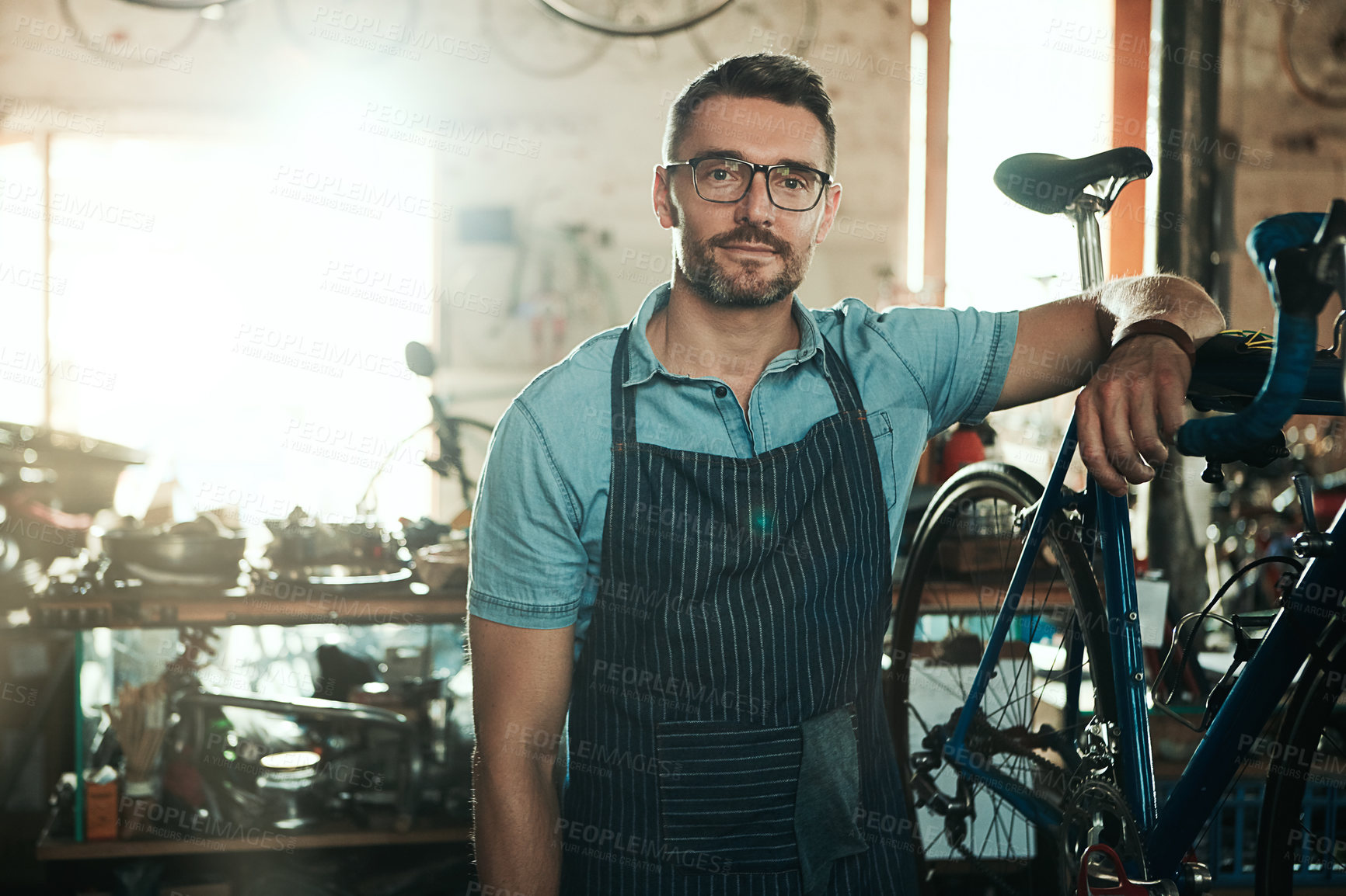 Buy stock photo Portrait, serious and man with bike for technician career, small business and entrepreneur in maintenance garage. Mature guy, bicycle mechanic and professional skills for repair in service workshop