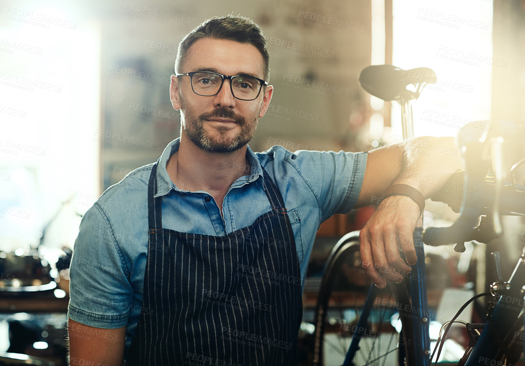 Buy stock photo Portrait, happy and man with bicycle for mechanic career, business owner and working in maintenance garage. Mature male person, bike technician and professional skills for repair in service workshop