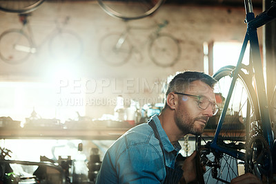 Buy stock photo Man, garage and serious as bicycle mechanic with equipment in startup and small business. Workshop, expert and diy as handyman with fixing bike at repair or maintenance shop and entrepreneur