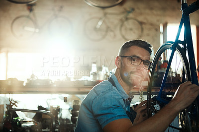Buy stock photo Man, workshop and happy as bicycle mechanic with equipment in startup and small business. Garage, expert and smile in portrait as handyman with fixing bike at repair or maintenance shop and diy