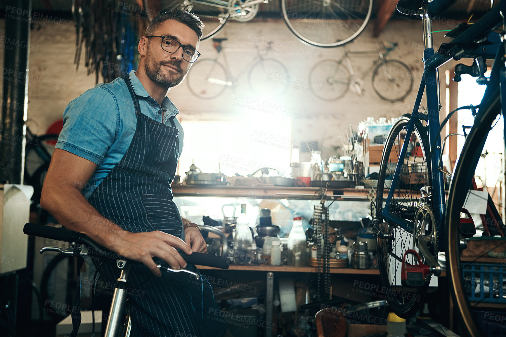 Buy stock photo Portrait of a mature man working in a bicycle repair shop