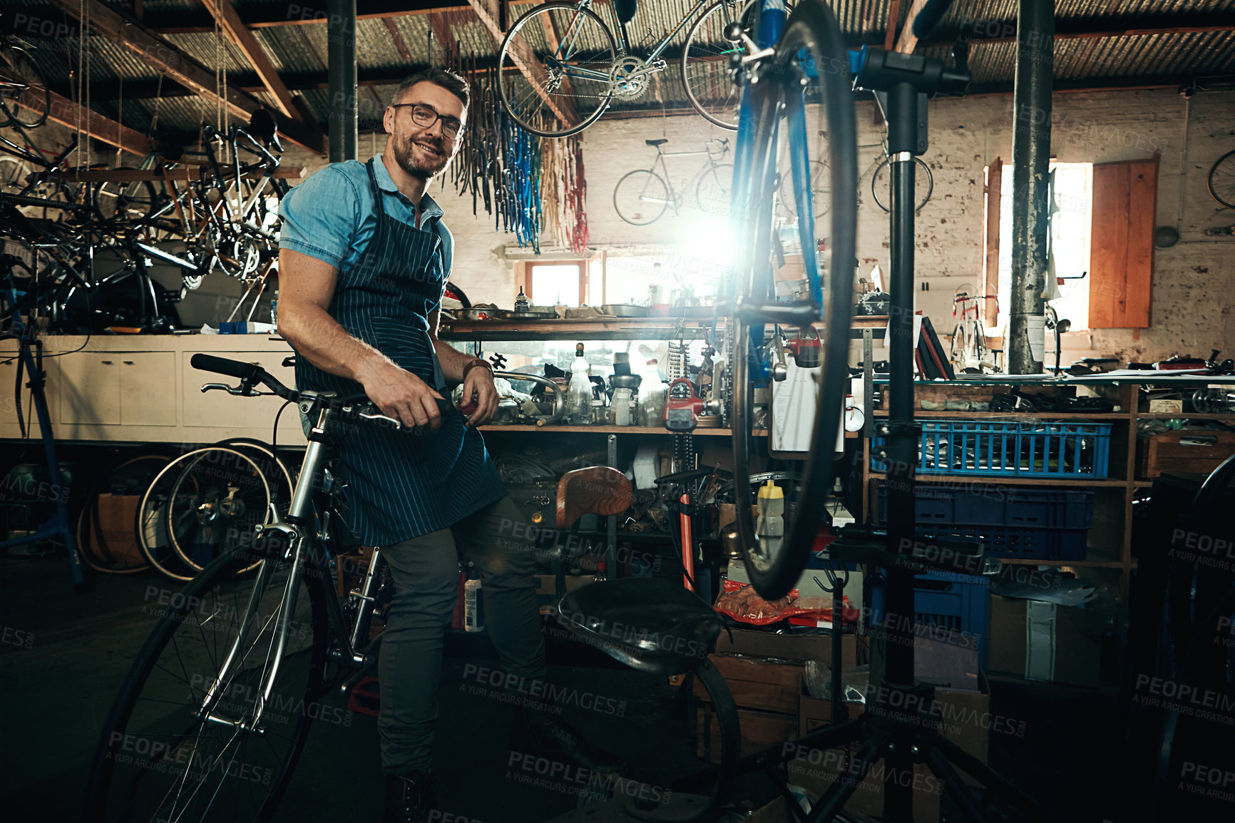 Buy stock photo Portrait of a mature man working in a bicycle repair shop