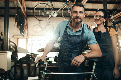 Buy stock photo Portrait of a man and woman working together in a bicycle repair shop