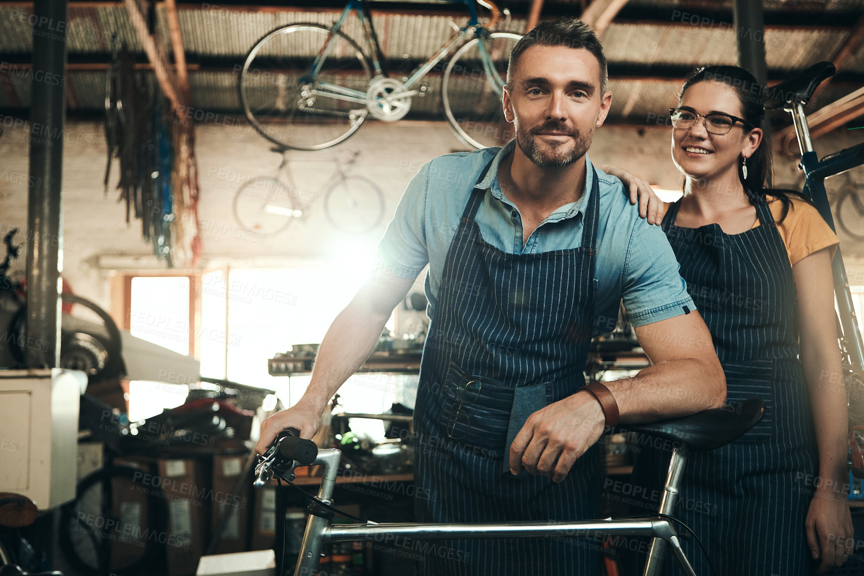 Buy stock photo Man, woman and bicycle shop with smile for maintenance job, startup with transport service. Bike, mechanic and entrepreneur couple in workshop, happiness for sustainable business with travel