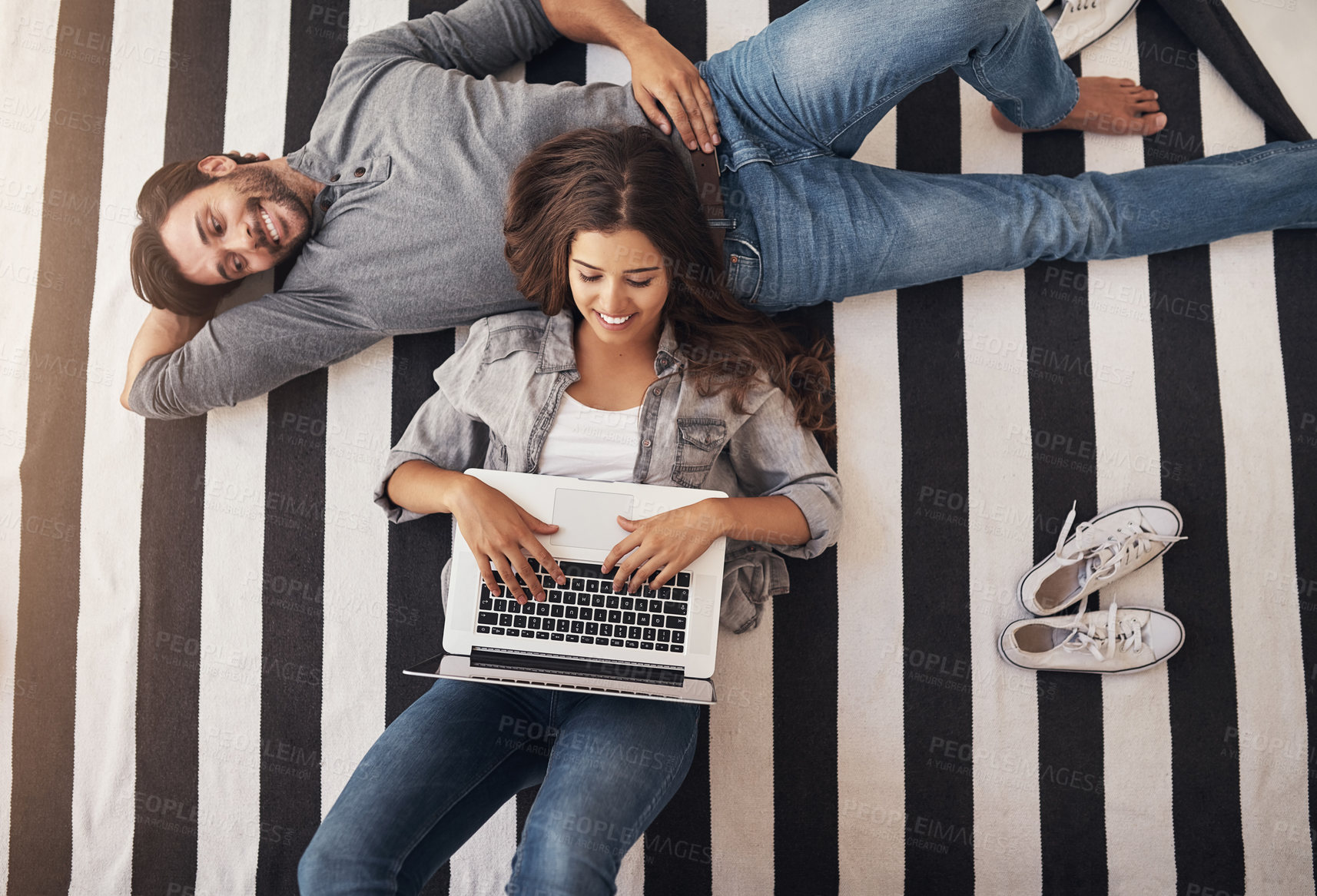 Buy stock photo Relax, laptop and couple on floor in home with smile, bonding and streaming movie from above. Computer, man and woman on carpet with online search, connection or calm weekend morning in living room