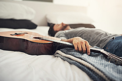 Buy stock photo Shot of a young handsome man sleeping next to his guitar at home