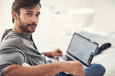 Buy stock photo Shot of a handsome young man surfing the net at home