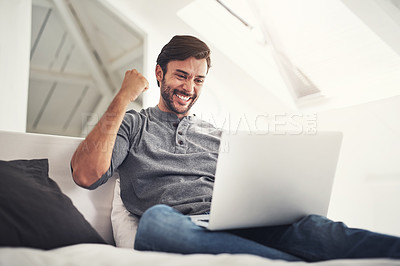 Buy stock photo Shot of a handsome young man surfing the net at home