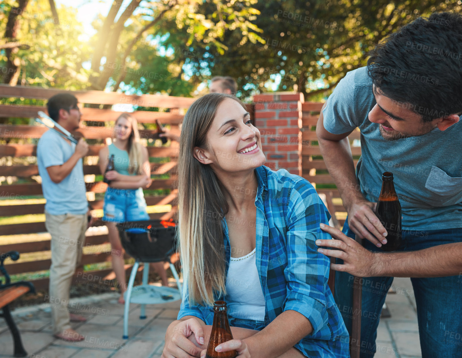 Buy stock photo Barbecue, happy and friends with drink in backyard for social event, gathering or summer hang out. Smile, beer and young man and woman in conversation for bonding at grill party at outdoor patio.