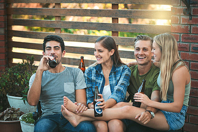 Buy stock photo Shot of a group of friends hanging out together and having beers