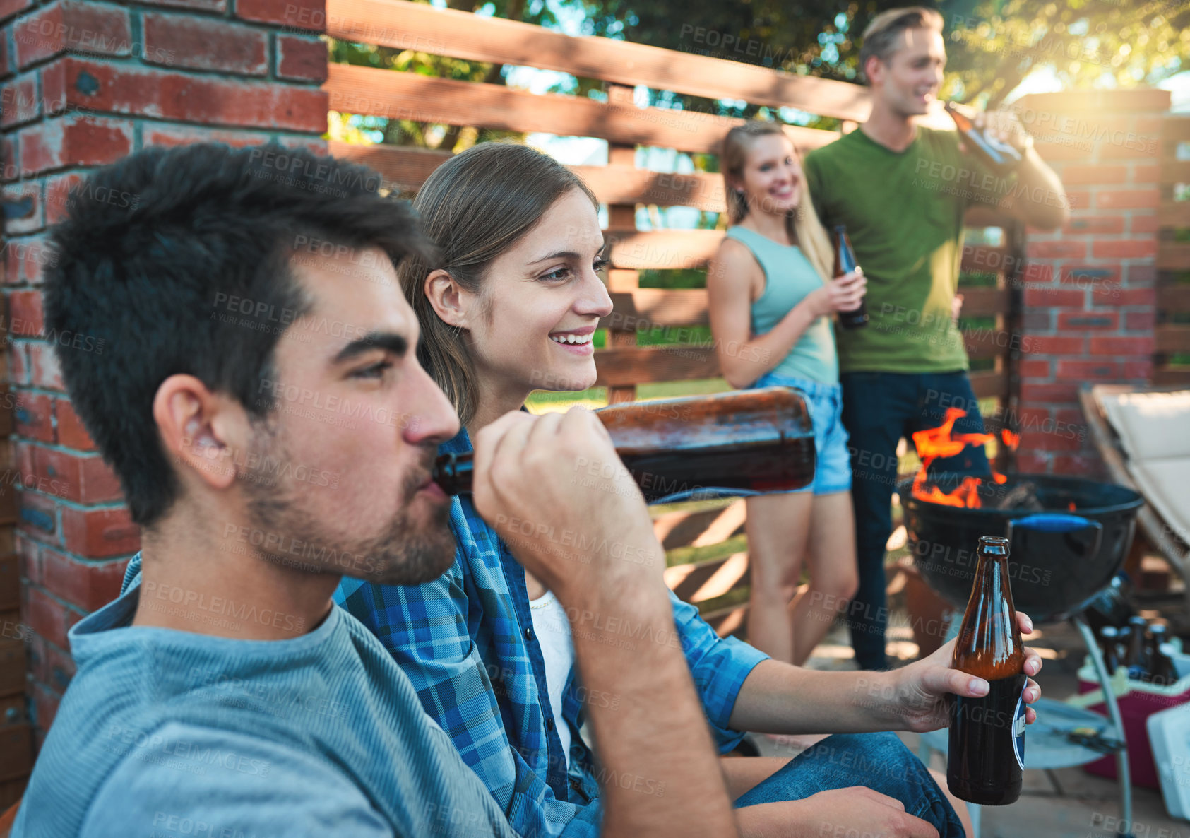 Buy stock photo Shot of a group of friends having beers together at a barbecue