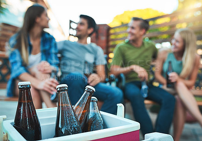 Buy stock photo Couple of friends, drinks and backyard party by cooler box for summer celebration and social hangout. People or group relax together with cold beverage, beer or alcohol bottle in ice on patio at home