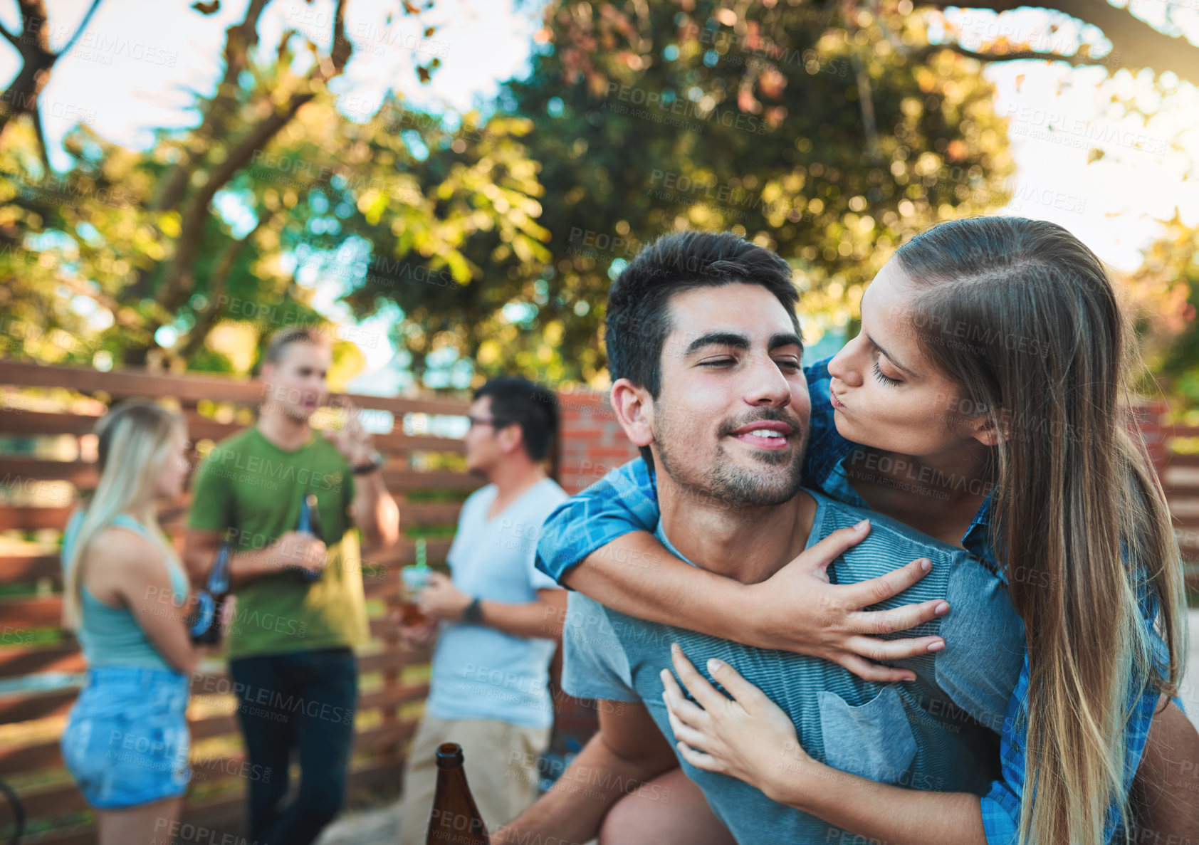 Buy stock photo Couple, hug and fun backyard with friends, love and outdoor at labor day party and social event. Beer, conversation and happy people with summer, vacation and group reunion with smile and care