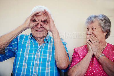 Buy stock photo Shot of a senior couple making funny faces outside