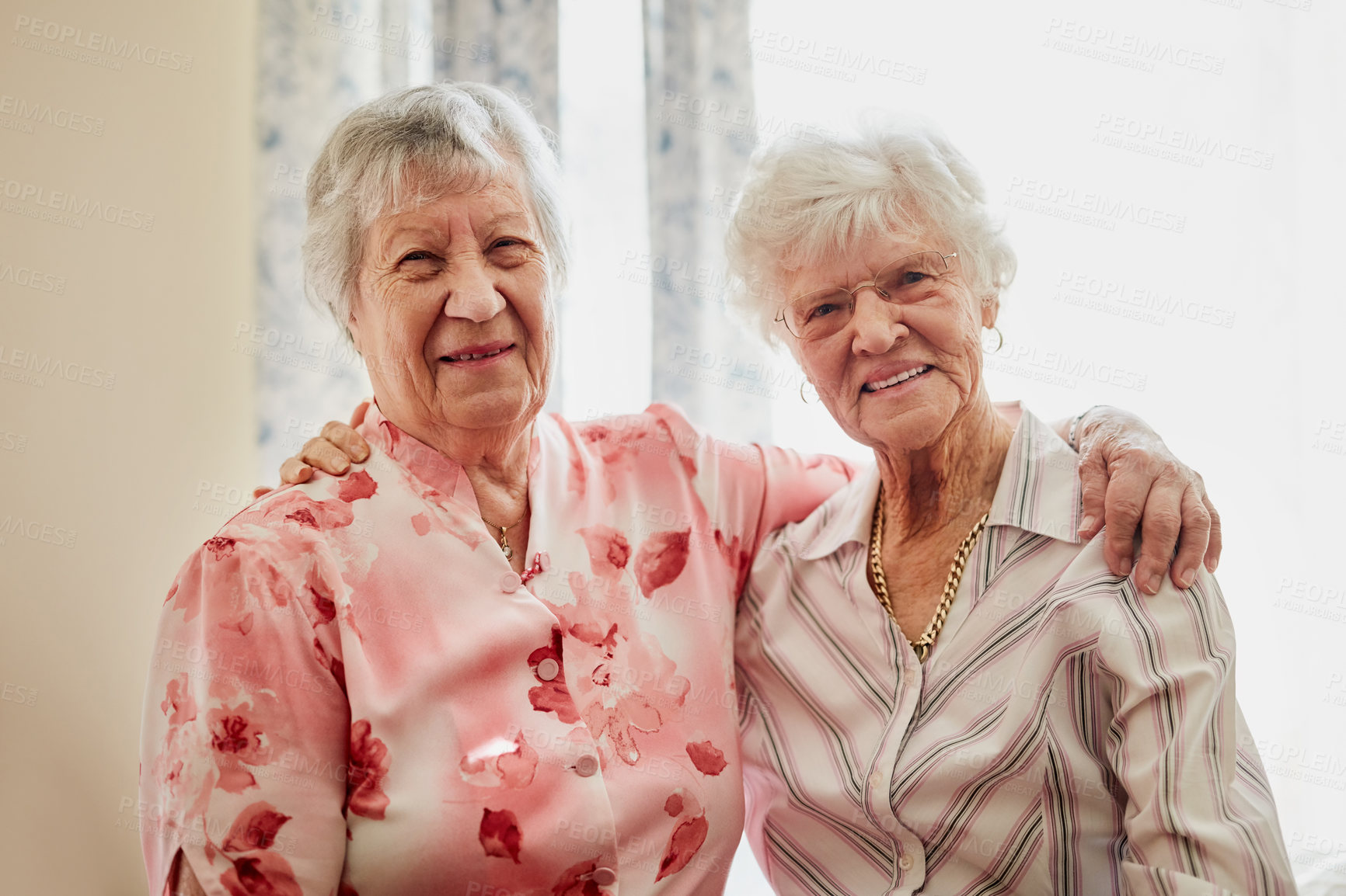 Buy stock photo Friends, senior women and happy in retirement home with hug or joy and fun. Pensioner, portrait and smile or confident in bonding to relax on break at old age house for wellbeing, wellness and health