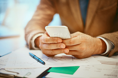 Buy stock photo High angle shot of an unrecognizable male designer sending a text message from his desk in the office