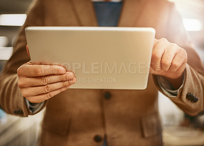 Buy stock photo Low angle shot of an unrecognizable male designer working on a tablet in his office