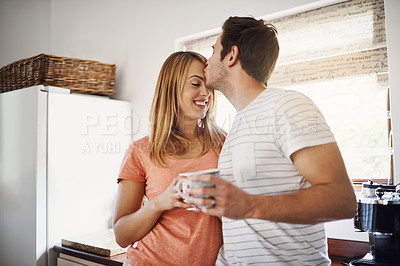 Buy stock photo Shot of an affectionate young couple enjoying coffee together in the morning at home