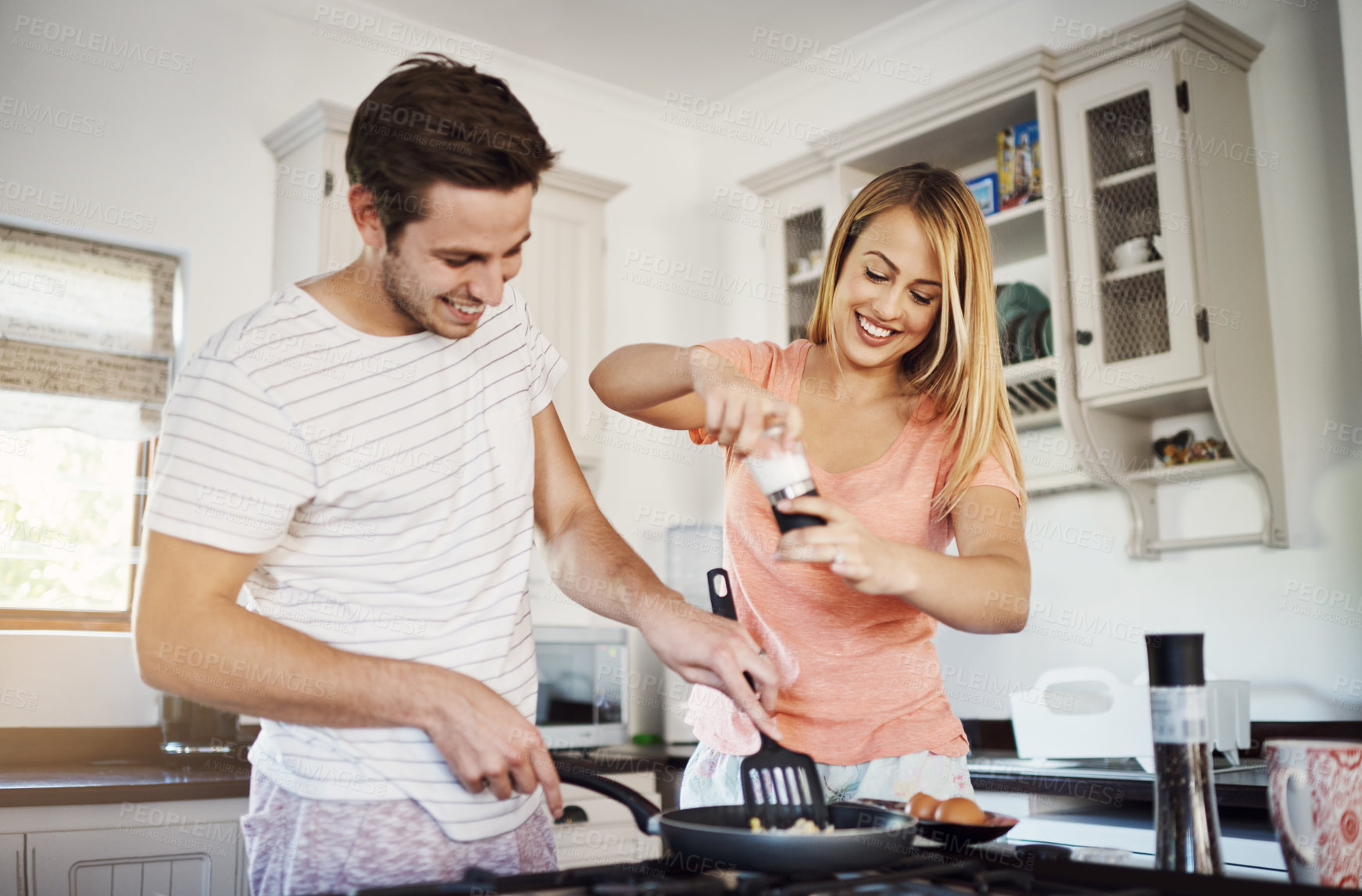 Buy stock photo Couple, cooking and helping with food in home, frying pan and salt on eggs for nutrition. Happy people, meal preparation and bonding together on weekend, morning breakfast and love in relationship