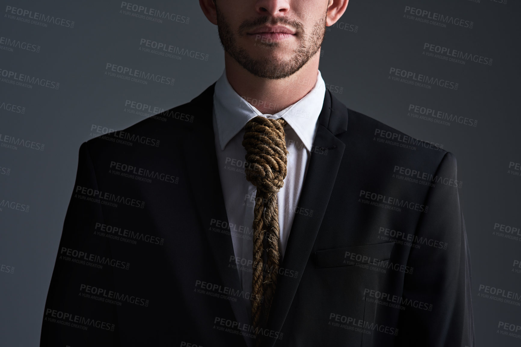 Buy stock photo Cropped studio shot of a businessman with a noose tied around his neck for a tie against a gray background