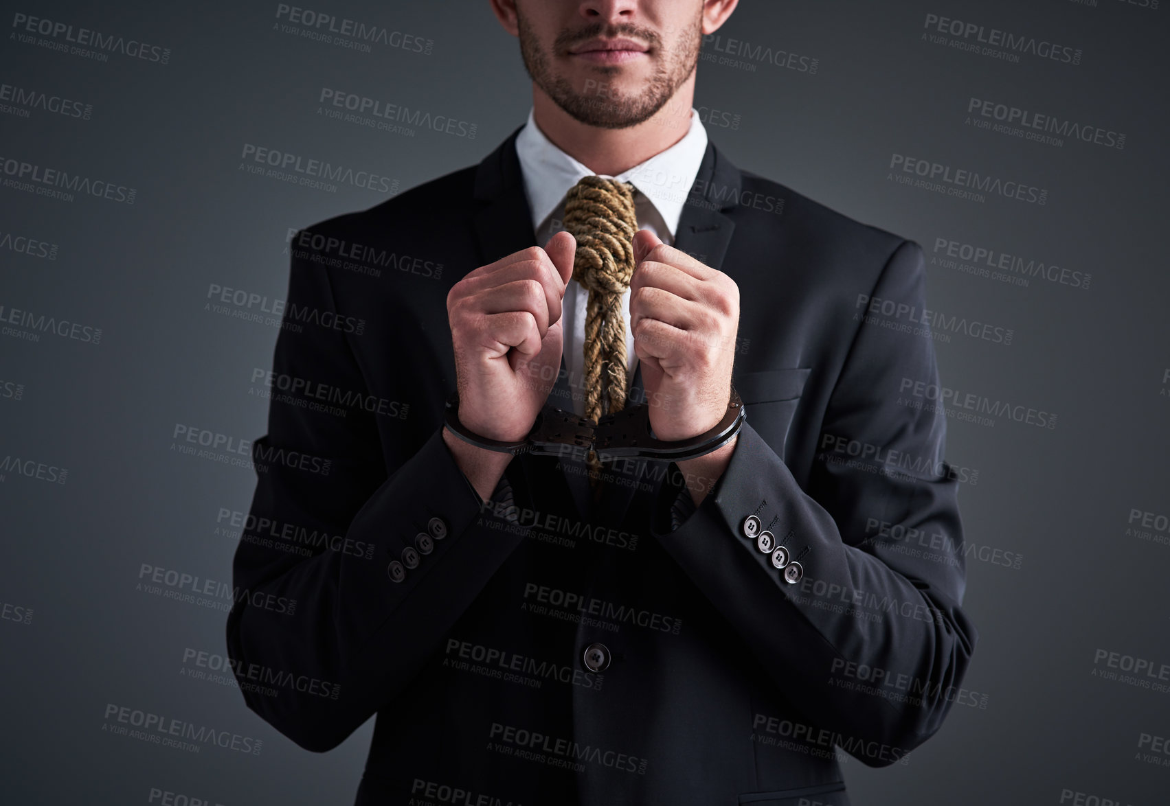 Buy stock photo Studio shot of a handcuffed businessman with a noose tied around his neck for a tie against a gray background