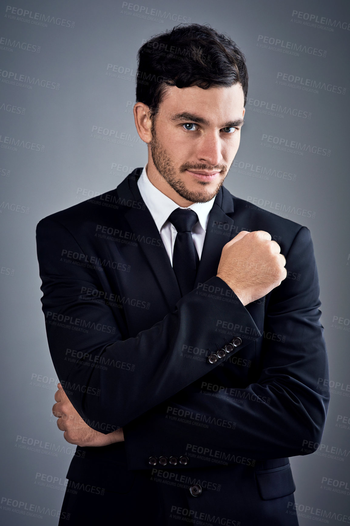 Buy stock photo Studio portrait of a handsome young businessman dressed in a suit against a grey background