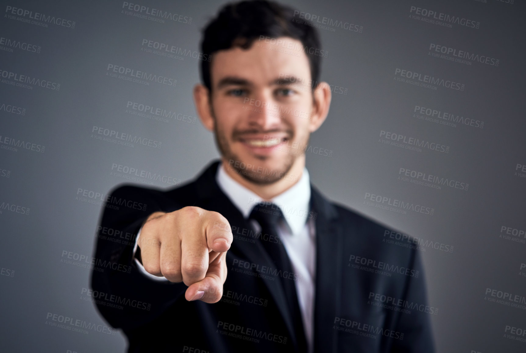 Buy stock photo Studio portrait of a young businessman pointing at you against a gray background