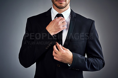 Buy stock photo Cropped studio shot of a young businessman dressed in a suit against a grey background