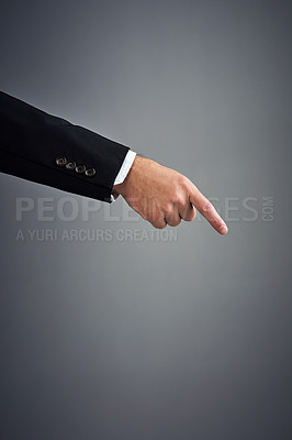 Buy stock photo Cropped studio shot of a businessman’s hand pointing downwards against a gray background