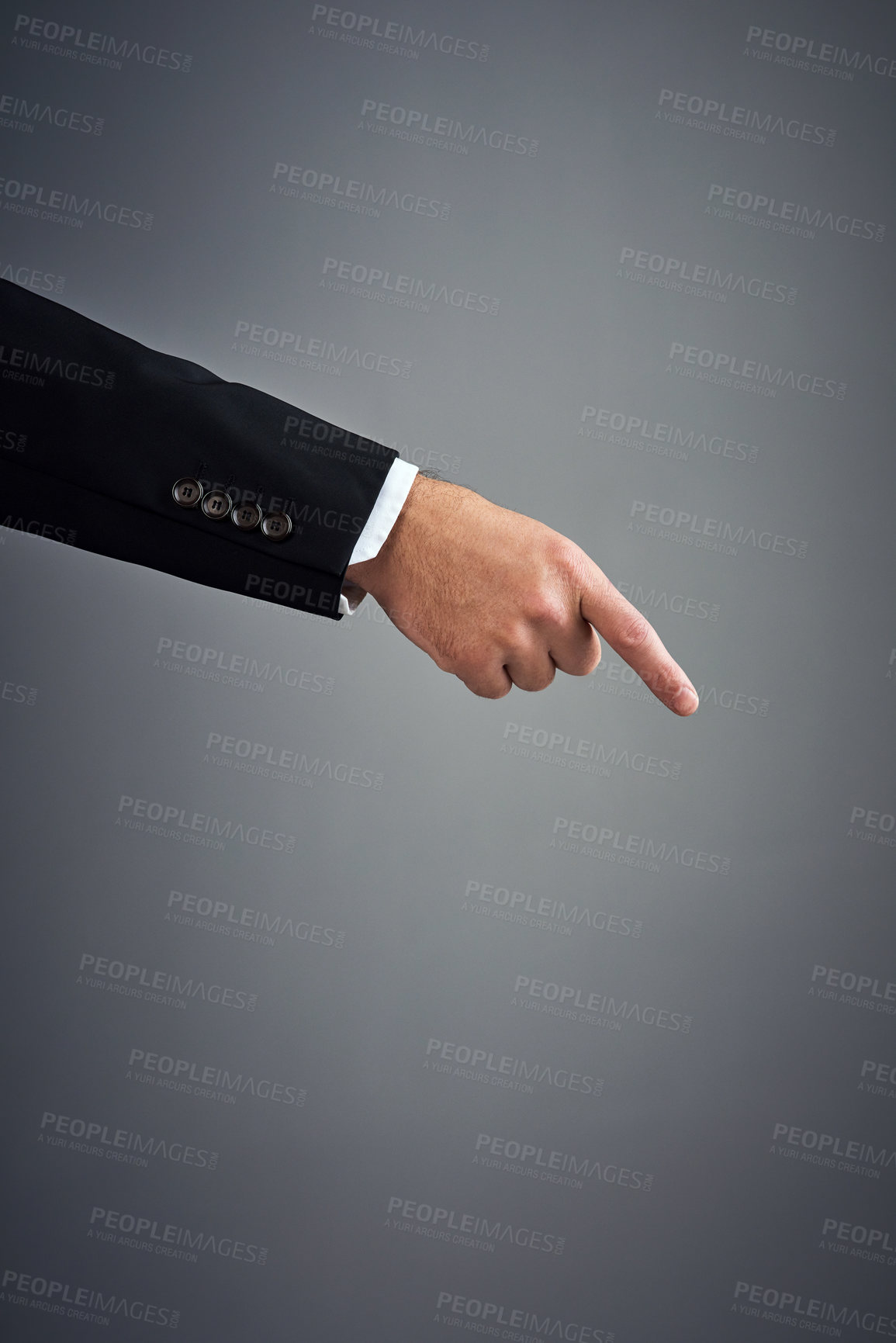 Buy stock photo Cropped studio shot of a businessman’s hand pointing downwards against a gray background