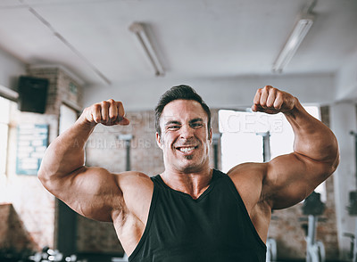 Buy stock photo Cropped shot of a young man flexing his muscles