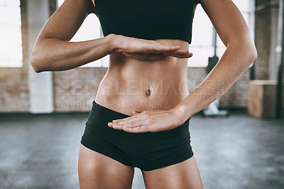 Buy stock photo Cropped shot of a woman framing her stomach with her hands