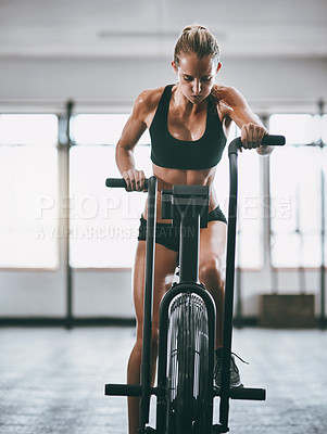 Buy stock photo Shot of a woman working out on a elliptical machine