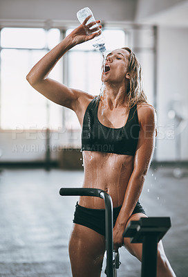Buy stock photo Shot of a young woman pouring water over her face after a serious workout