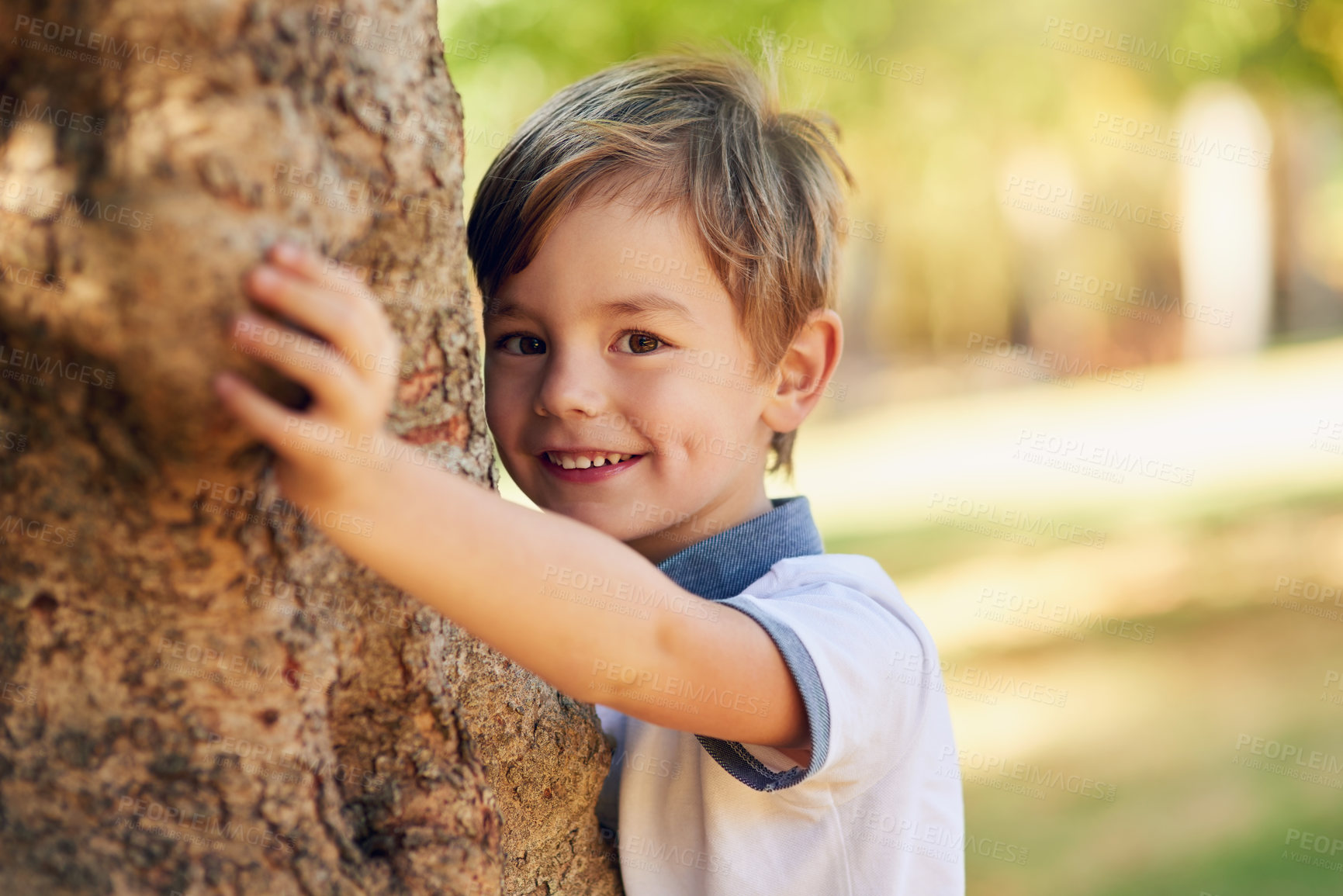 Buy stock photo Boy, hide and game by tree for portrait in park for playing, excited and outdoor for adventure in summer. Child, nature and smile in forest for holiday, vacation and freedom for climbing in Canada