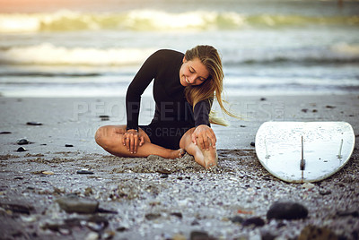 Buy stock photo Full length shot of an attractive young female surfer warming up on the beach