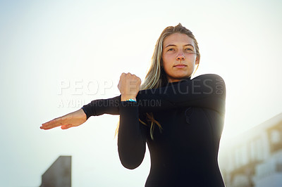 Buy stock photo Cropped shot of an attractive young female surfer warming up on the beach