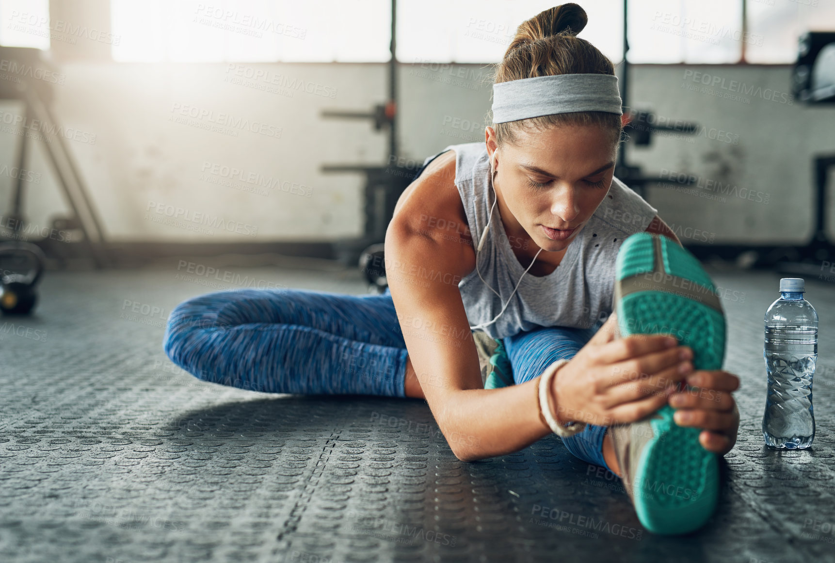 Buy stock photo Shot of a young attractive woman stretching in a gym