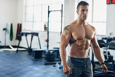 Buy stock photo Shot of a handsome young man working out at the gym