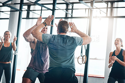 Buy stock photo Shot of a fitness group celebrating a victory at the gym