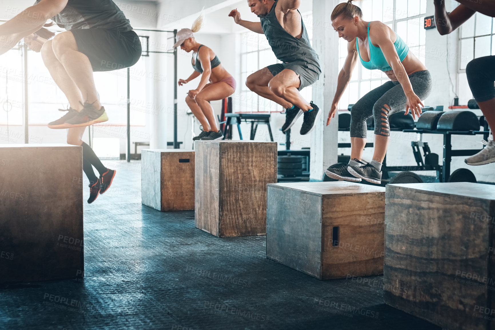 Buy stock photo Shot of a fitness group box jumping at the gym