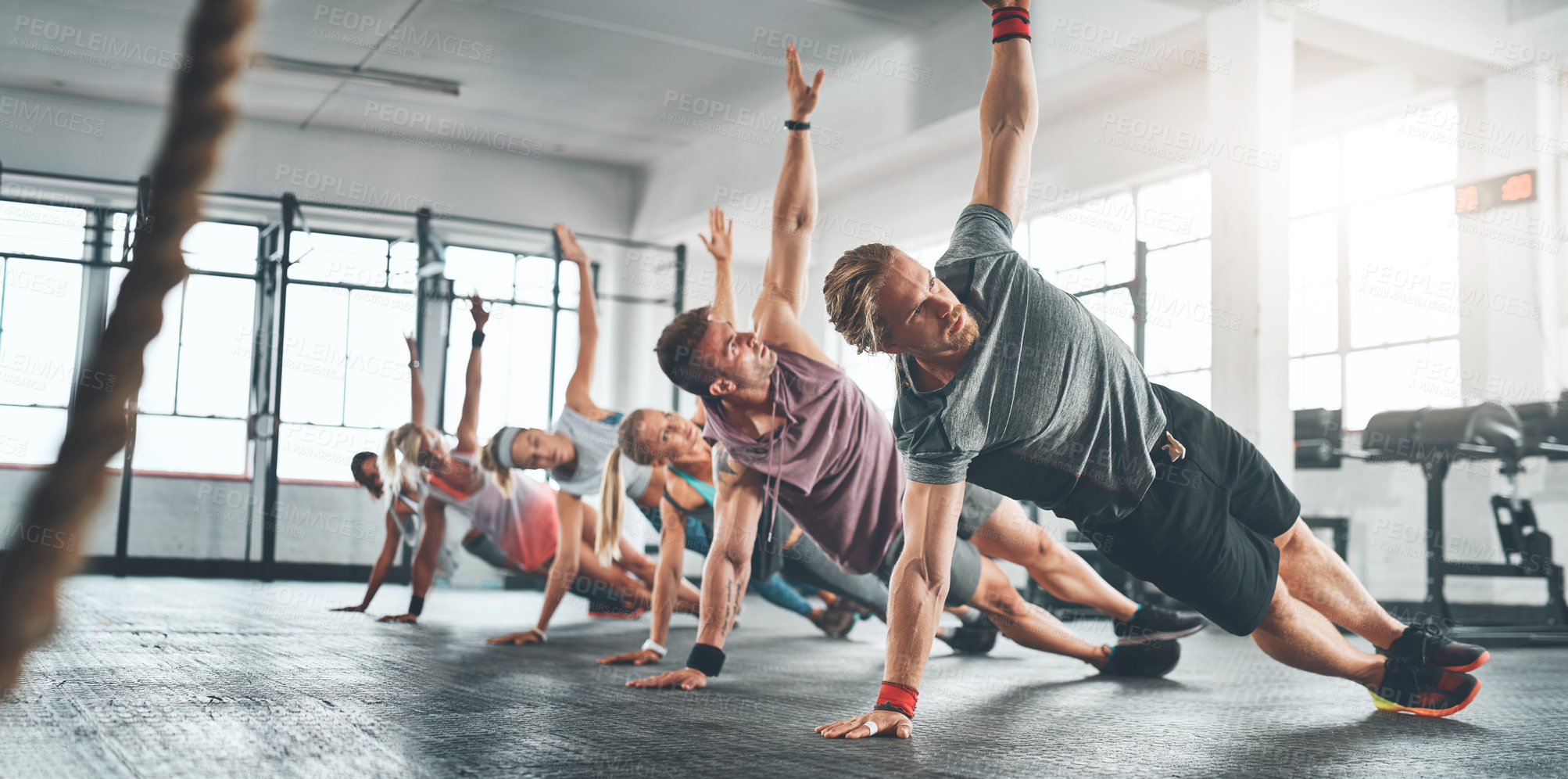 Buy stock photo Fitness class, group and people doing a workout in the gym for health, wellness and flexibility. Sports, training and athletes doing a side plank exercise challenge together in sport studio or center