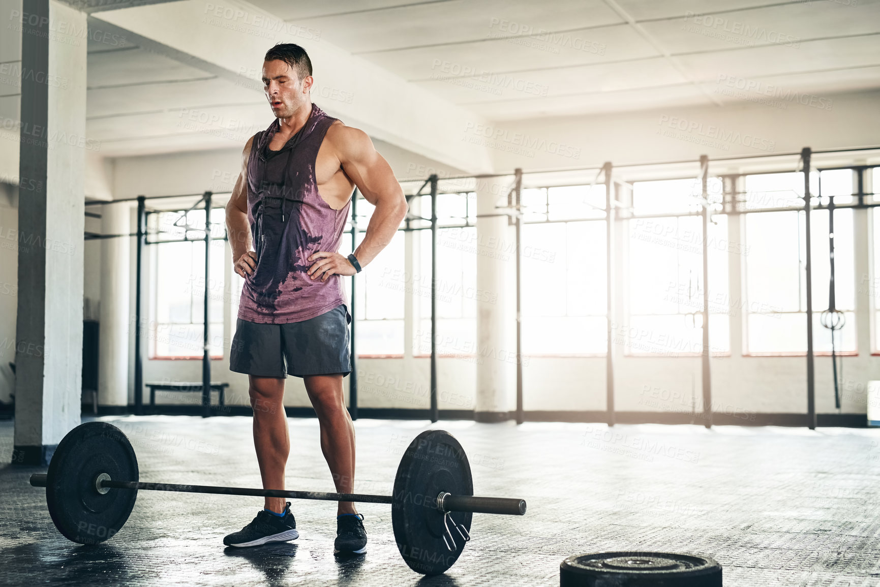 Buy stock photo Shot of a muscular young man lifting weights at the gym