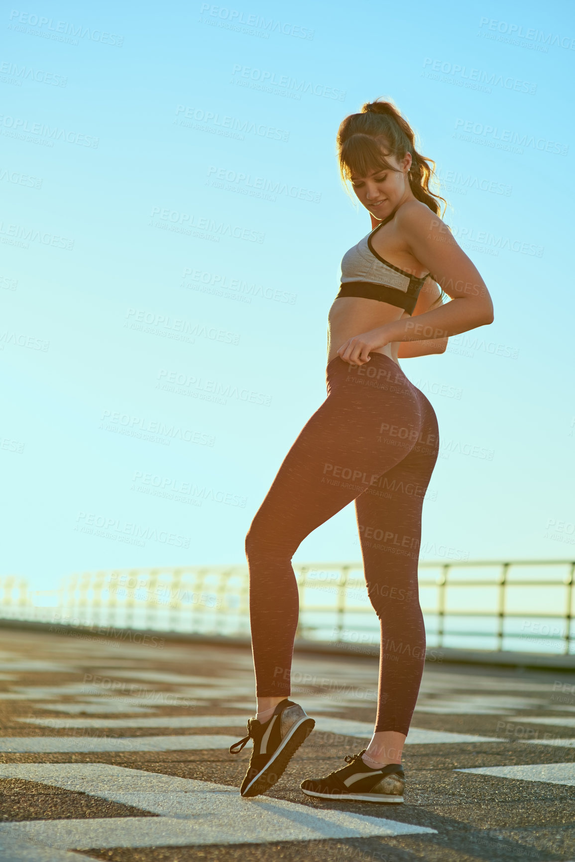 Buy stock photo Buttocks, fitness and running with woman on promenade outdoor for start of workout routine. Exercise, glutes or health and smile of sports person happy or satisfied with cardio training results