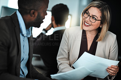 Buy stock photo Shot of two businesspeople discussing paperwork