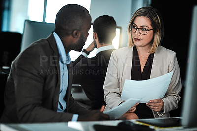 Buy stock photo Shot of two businesspeople discussing paperwork